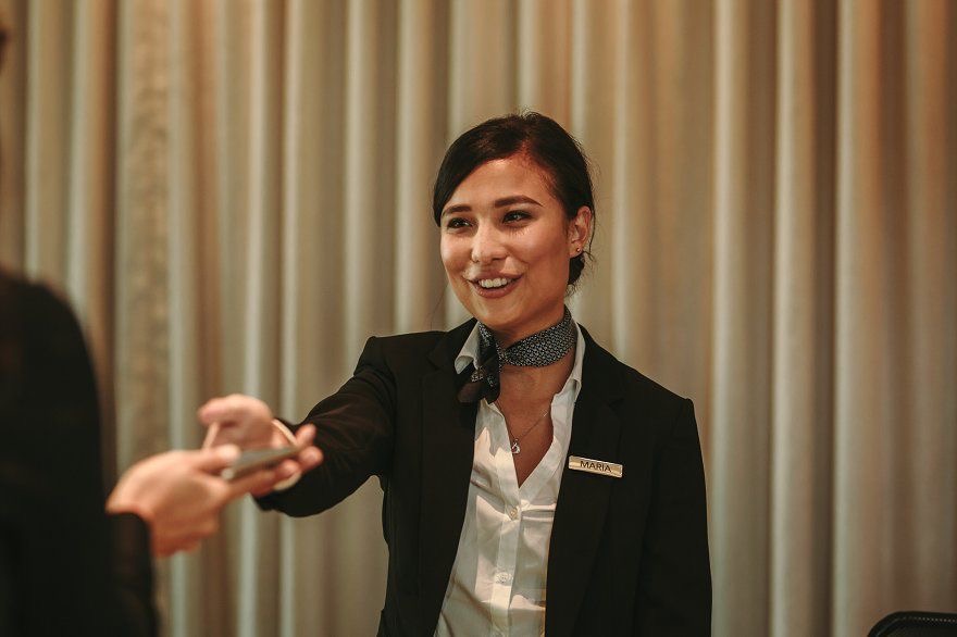 Photo of a woman working at a front desk in a hotel