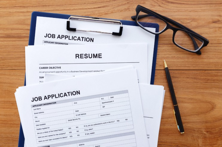 Photo of a resume, a pen and glasses