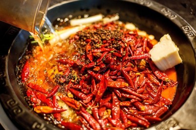 View of Chengdu's hotpot, a large pot with sauce and a large amount of chili peppers on top of it 