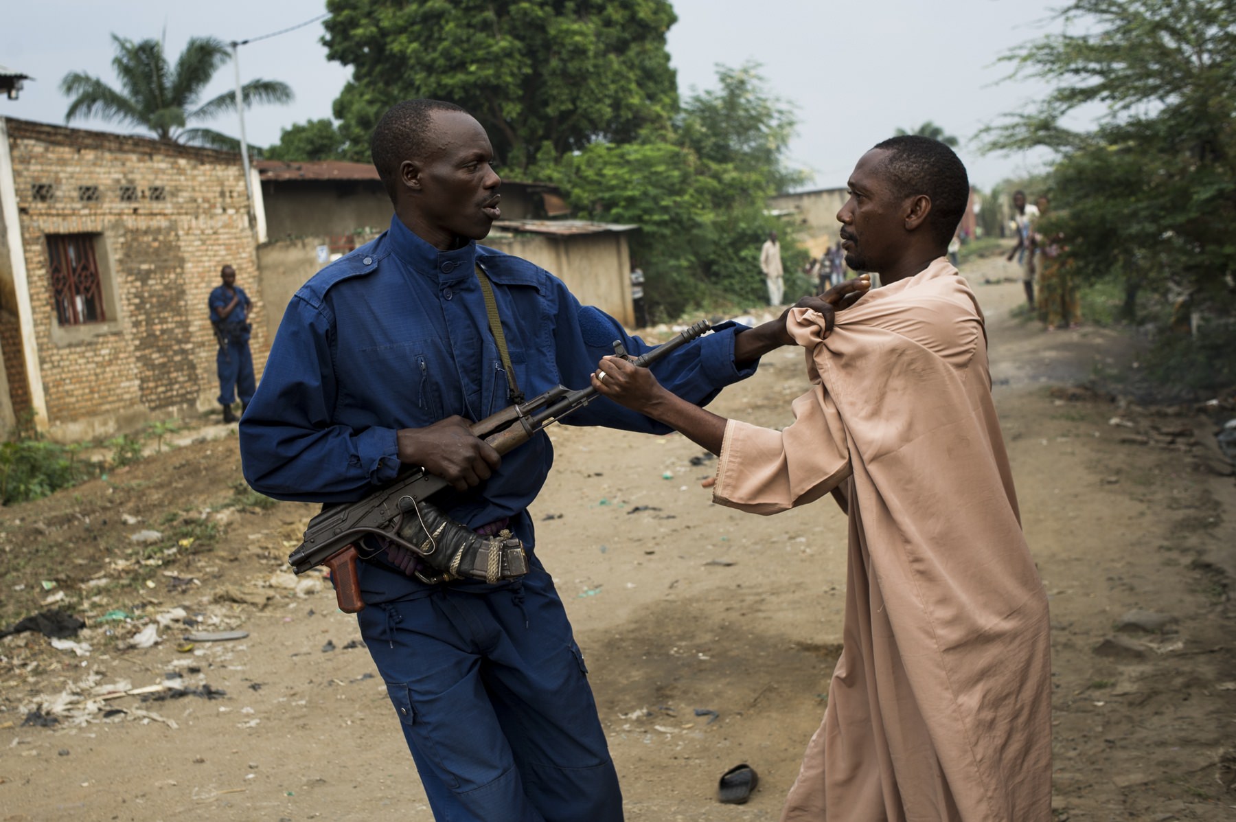 A policeman jostles with a resident of the largely opposition neighbourhood of Cibitoke in Bujumbura, Burundi, on June 27, 2015. Police conducted a raid on the neighbourhood this morning, searching for weapons and arresting a man they accused of being a leader of an opposition party, who they claim was hiding weapons.