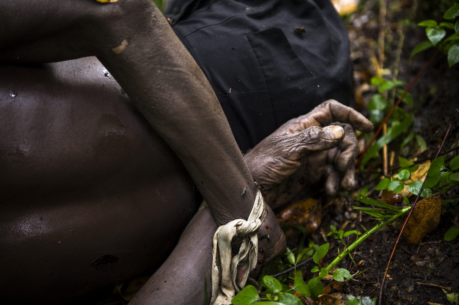 The bodies of two men killed near the village of Mabenga in the Democratic Republic of the Congo's restive North Kivu province, lie with their hands tied behind their backs in the jungle beside the Rwindi river on July 29, 2012. M23 rebels accuse the Congolese army of massacring up to 70 people here, throwing their bodies into the river. M23 claim that the army accused those killed of having a "familiar relationship" with the rebel group.